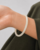 True worn macro of the complete ivory Arden Slim Resin Bangle around the wrist