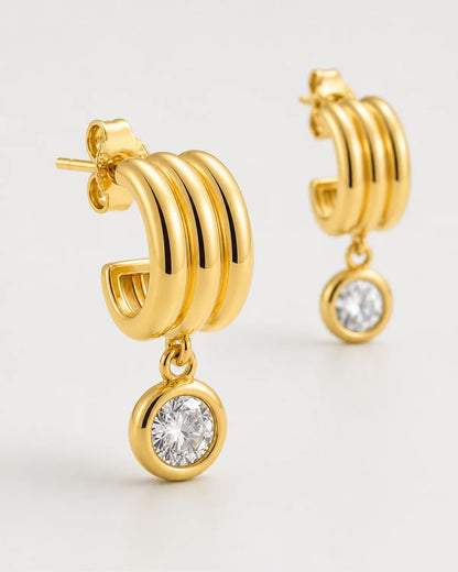 Three-quarter macro of an Astra three-arc mini hoop and round bezel zircon drop