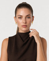 Human-scale studio view of the Astra earrings with espresso tailoring