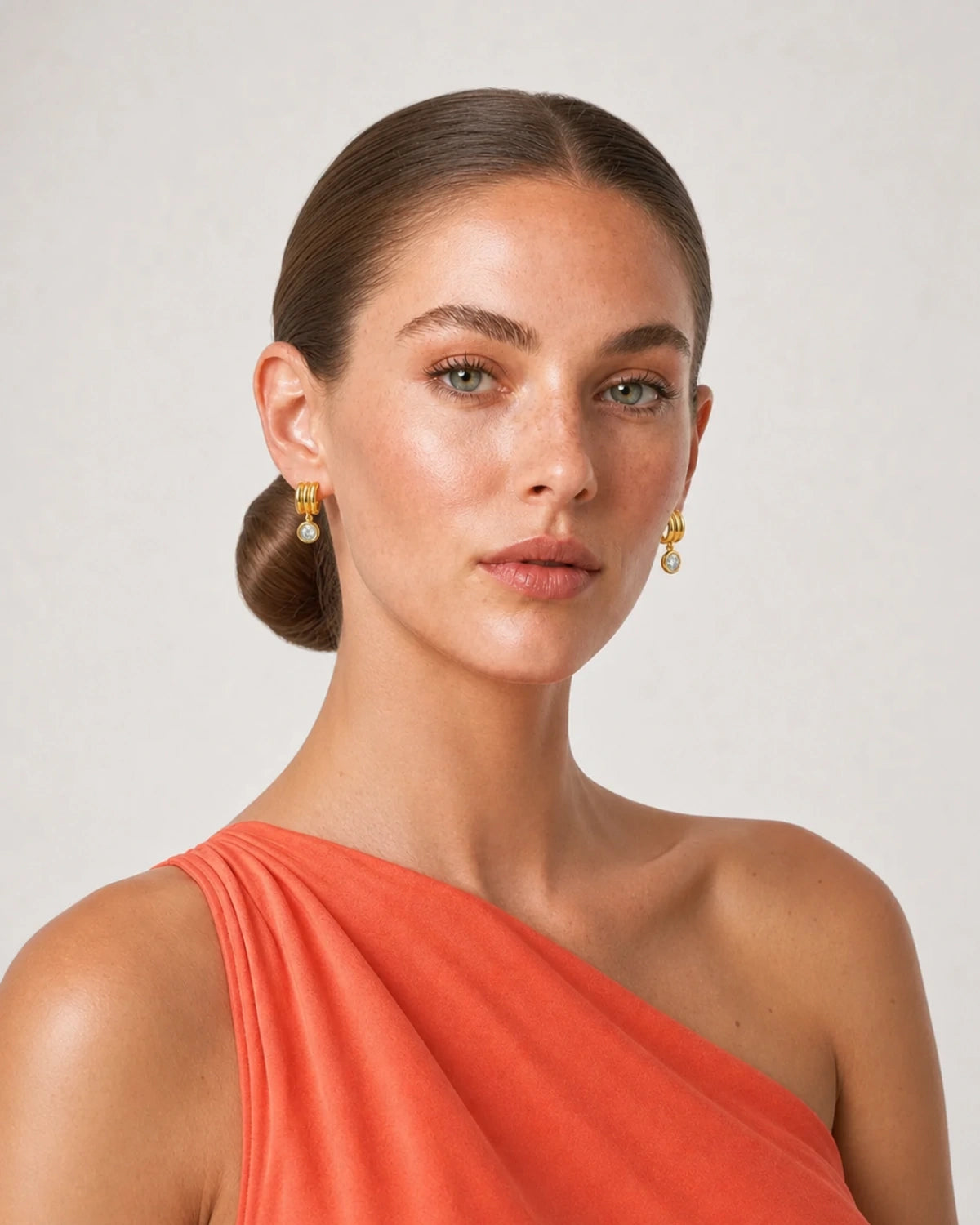 Three-quarter studio portrait of Freya wearing the Astra zircon drop earrings