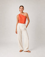 Full-body coral silk and ivory linen portrait featuring the Astra earrings