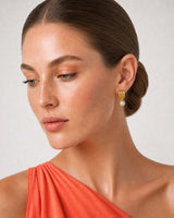 Close wearing view of an Astra three-arc earring and round bezel zircon