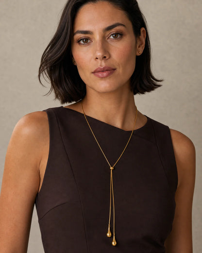 Bob-haired model wearing the Aurelia droplet lariat with a poised direct gaze