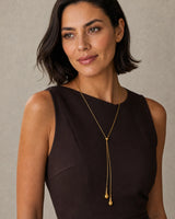 Bob-haired model wearing the Aurelia lariat at an alternate angle with a half-smile