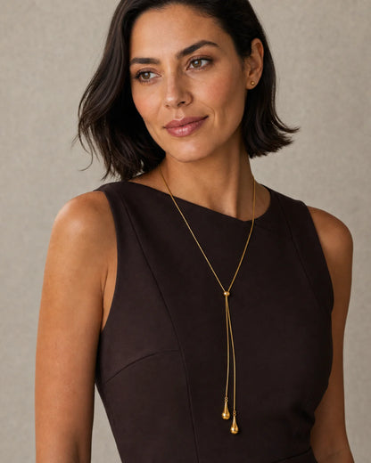 Bob-haired model wearing the Aurelia lariat at an alternate angle with a half-smile