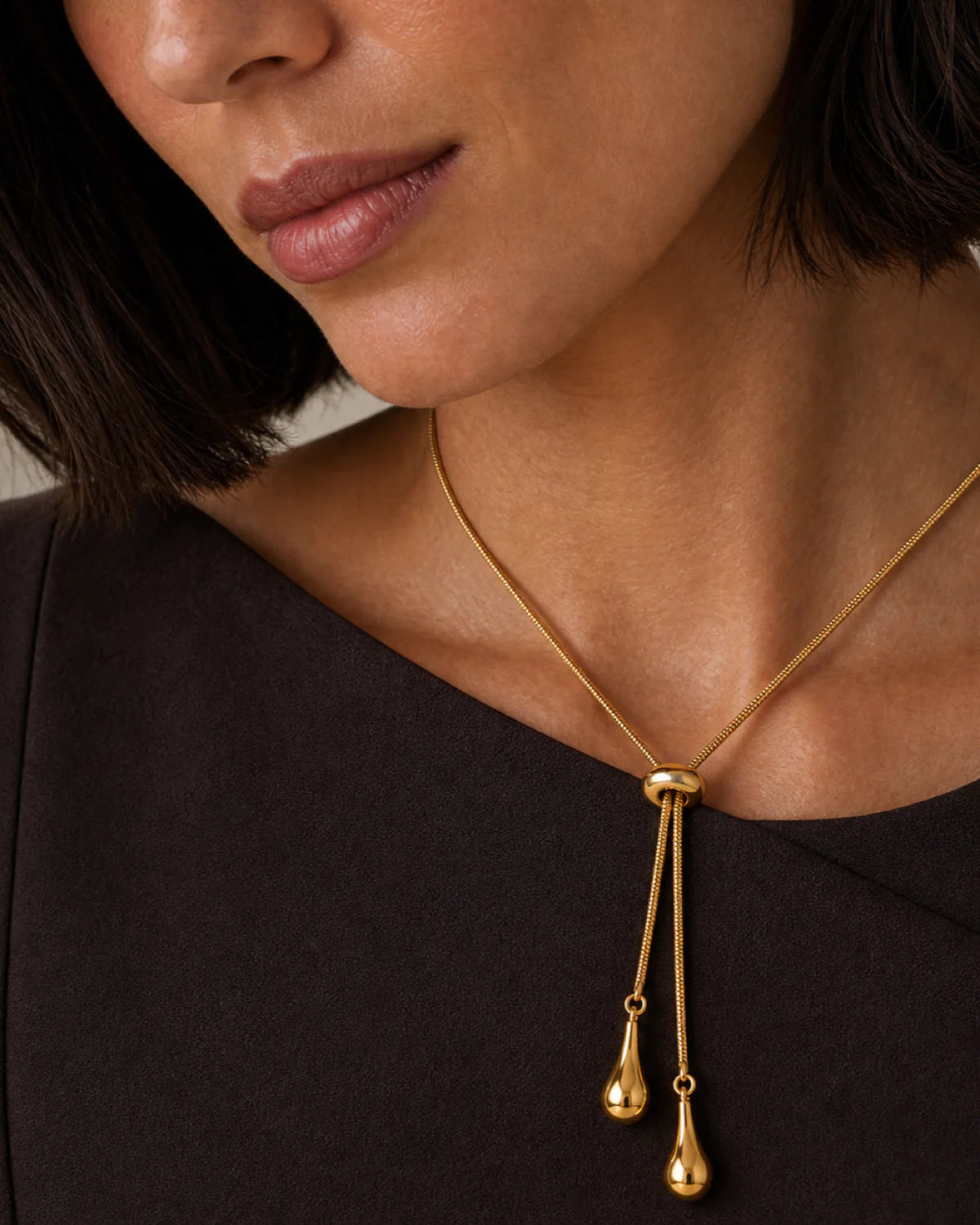 Extreme on-body macro of the Aurelia ring slider, snake chain and teardrop charms
