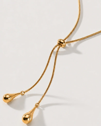 Macro detail of the Aurelia ring slider and polished teardrop charms on limestone
