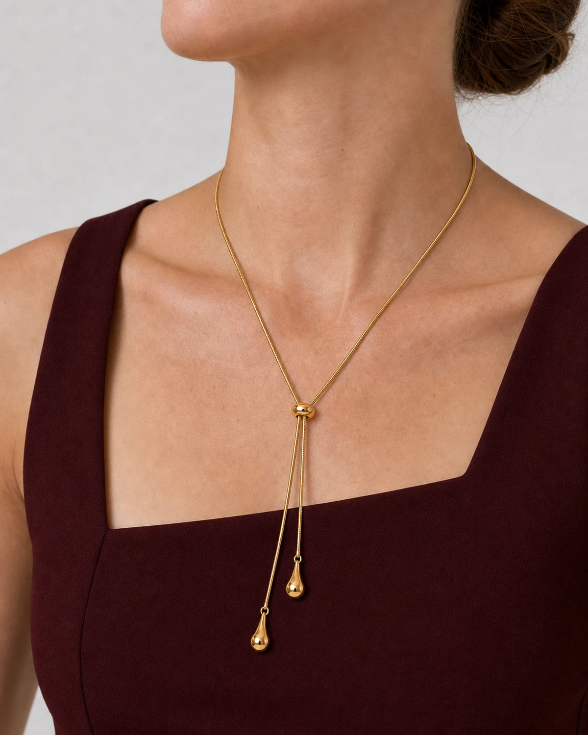 Three-quarter worn view of the Aurelia gold droplet lariat necklace