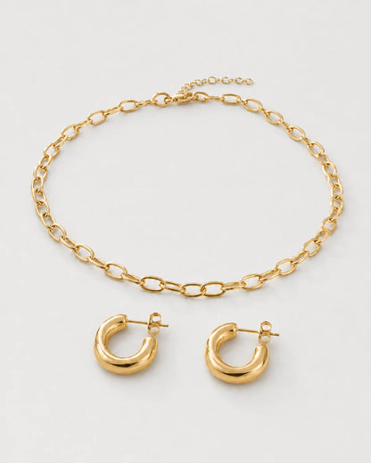 Aurelle gold oval-link necklace and sculpted hoop set on seamless pale dove-grey