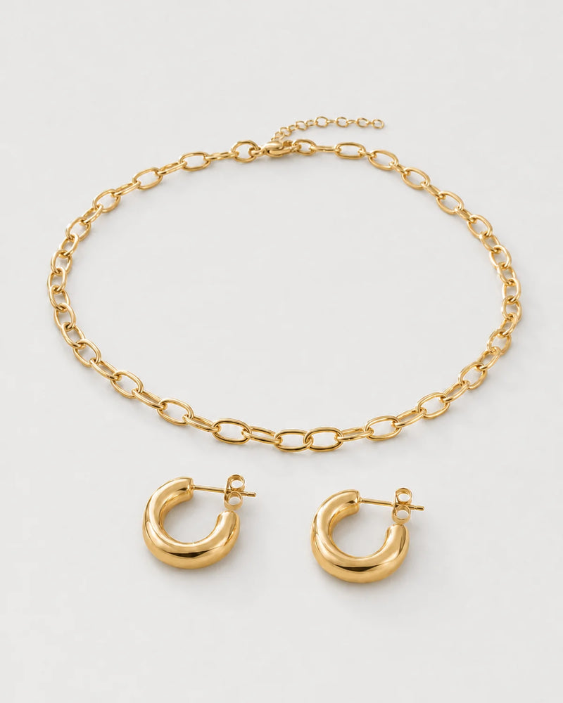 Aurelle gold oval-link necklace and sculpted hoop set on seamless pale dove-grey