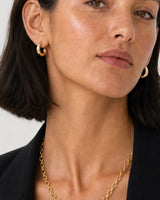 Clean close-up of the Aurelle sculpted hoops and gold oval-link necklace