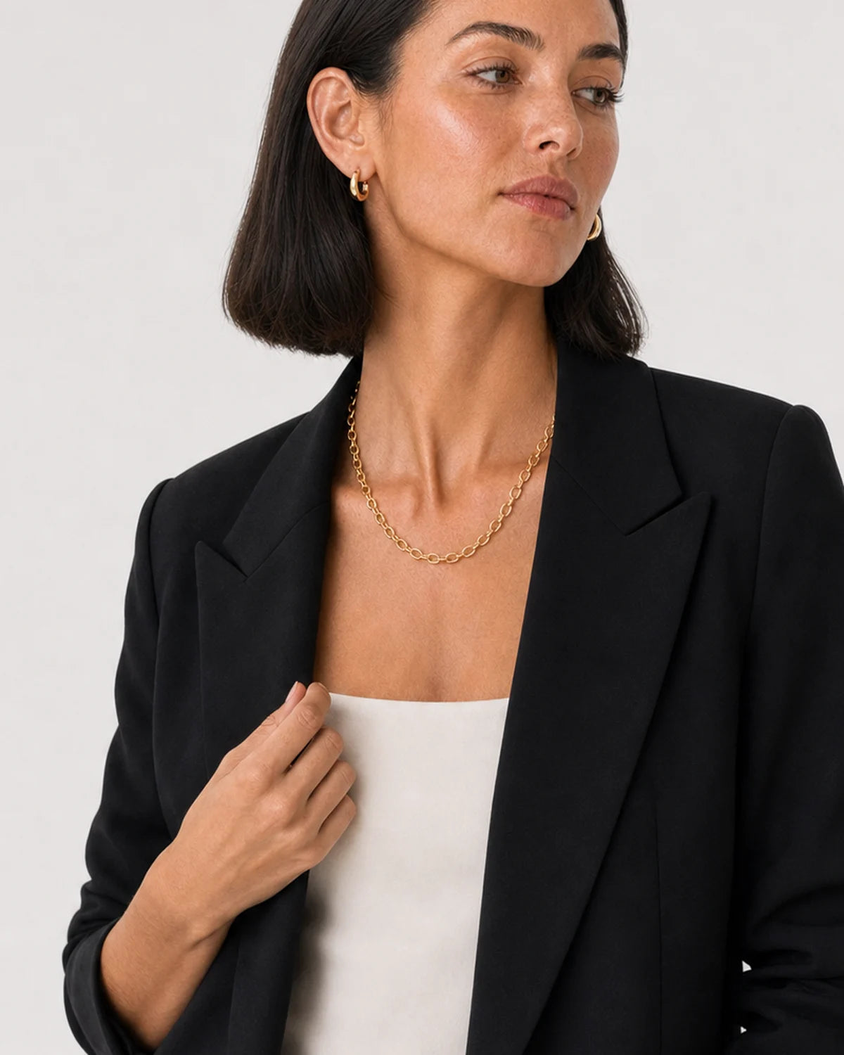 Human-scale styling view of the Aurelle jewellery set with black tailoring
