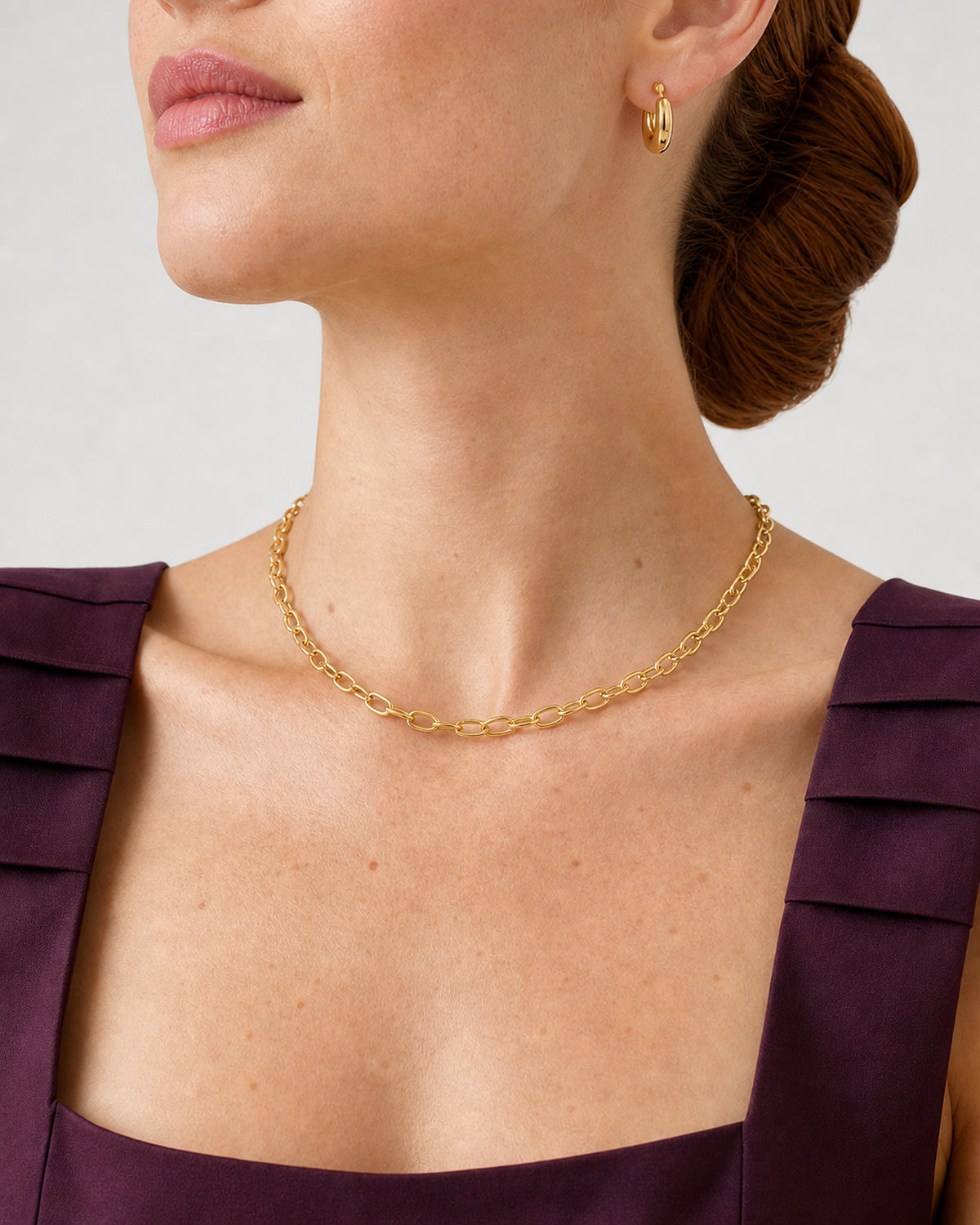 Three-quarter wearing view of the Aurelle gold necklace and compact open hoop
