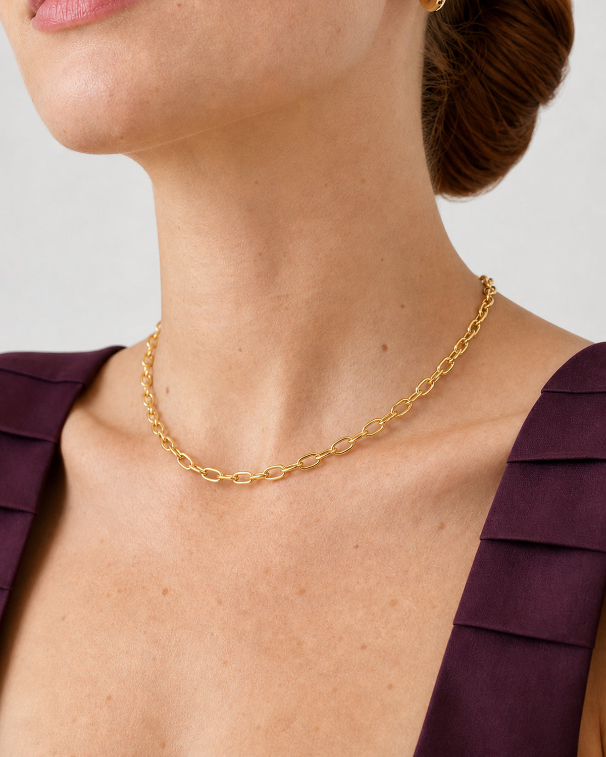 Complete worn macro of the Aurelle gold hoop and short oval-link necklace