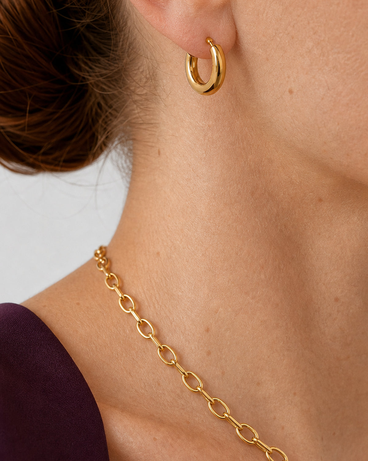 Extreme worn macro of the Aurelle gold open hoop and interlocking oval links