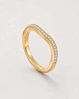 Aurelle gold wavy pavé band on pale dove-grey