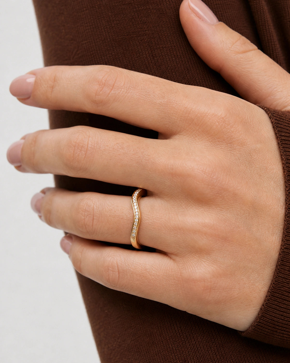 Complete worn macro of the Aurelle gold wavy pavé band