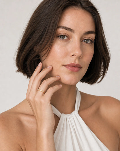 Model in a white Mykonos halter top wearing the Aurelle gold pavé band