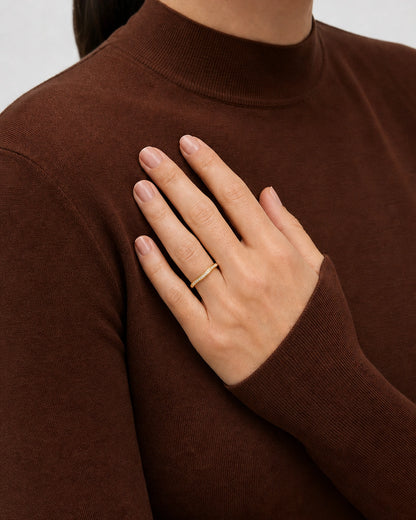 Aurelle gold pavé band worn in a soft hand-fan pose at the sternum