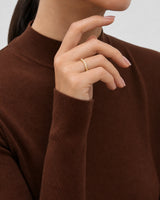Aurelle gold pavé band worn with the hand arcing beneath the lower jaw