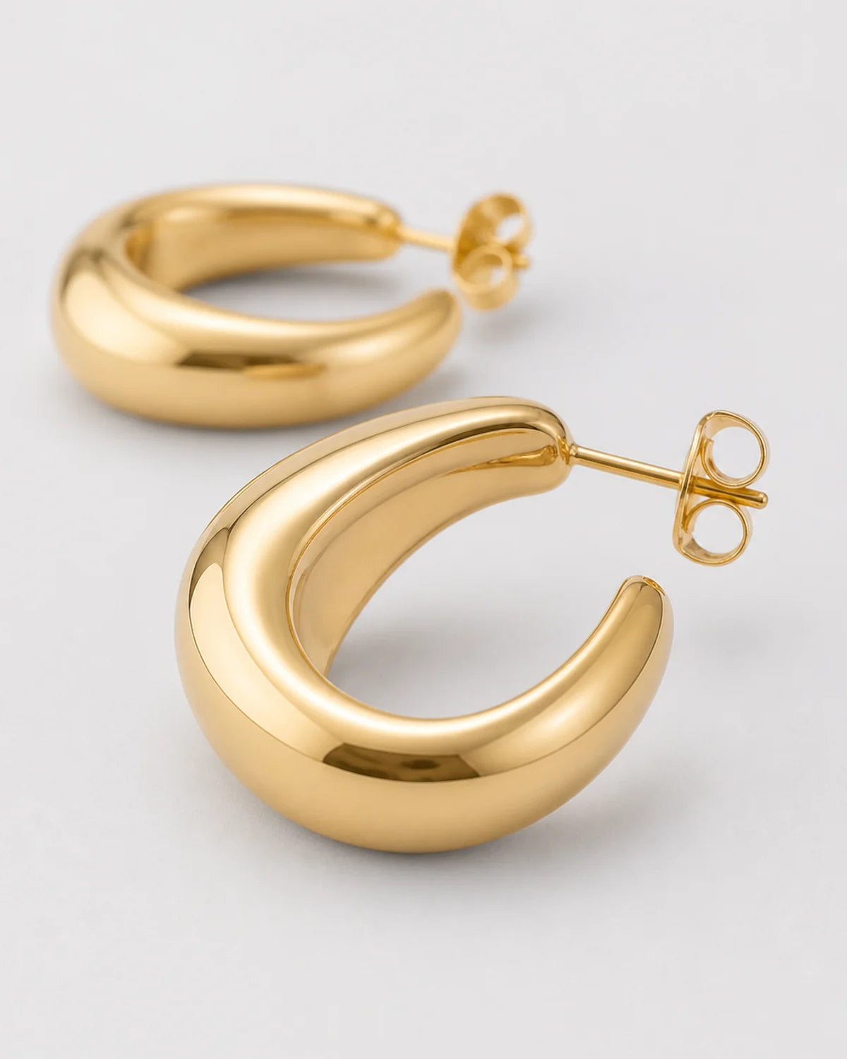 Macro detail of the Aurelle hoop's asymmetric tapered gold profile and post