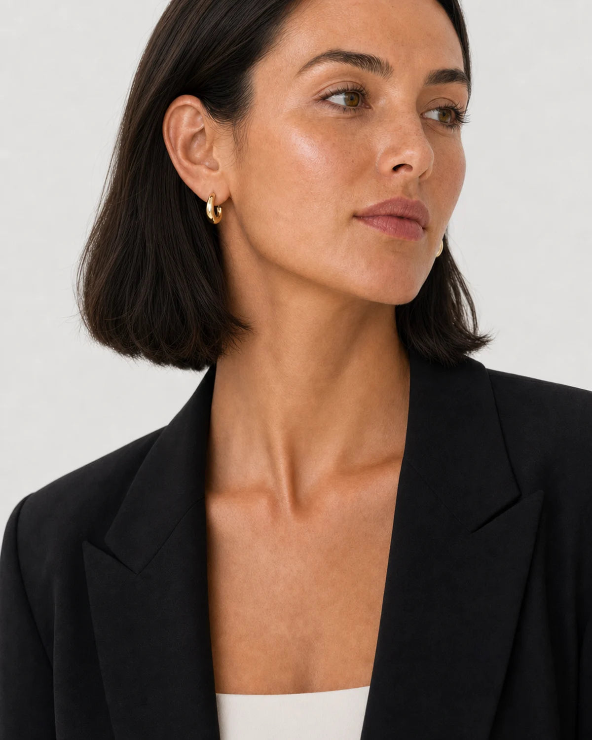 Alternate portrait of the same American model wearing the Aurelle sculpted hoops