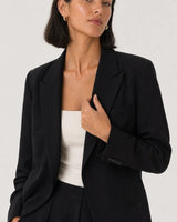 Wide editorial studio portrait showing the Aurelle sculpted hoops at natural scale