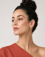 Alternate profile portrait wearing the Aurelle gold sculpted hoops