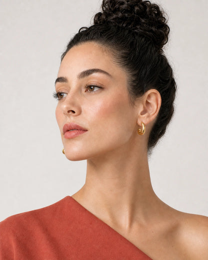 Alternate profile portrait wearing the Aurelle gold sculpted hoops