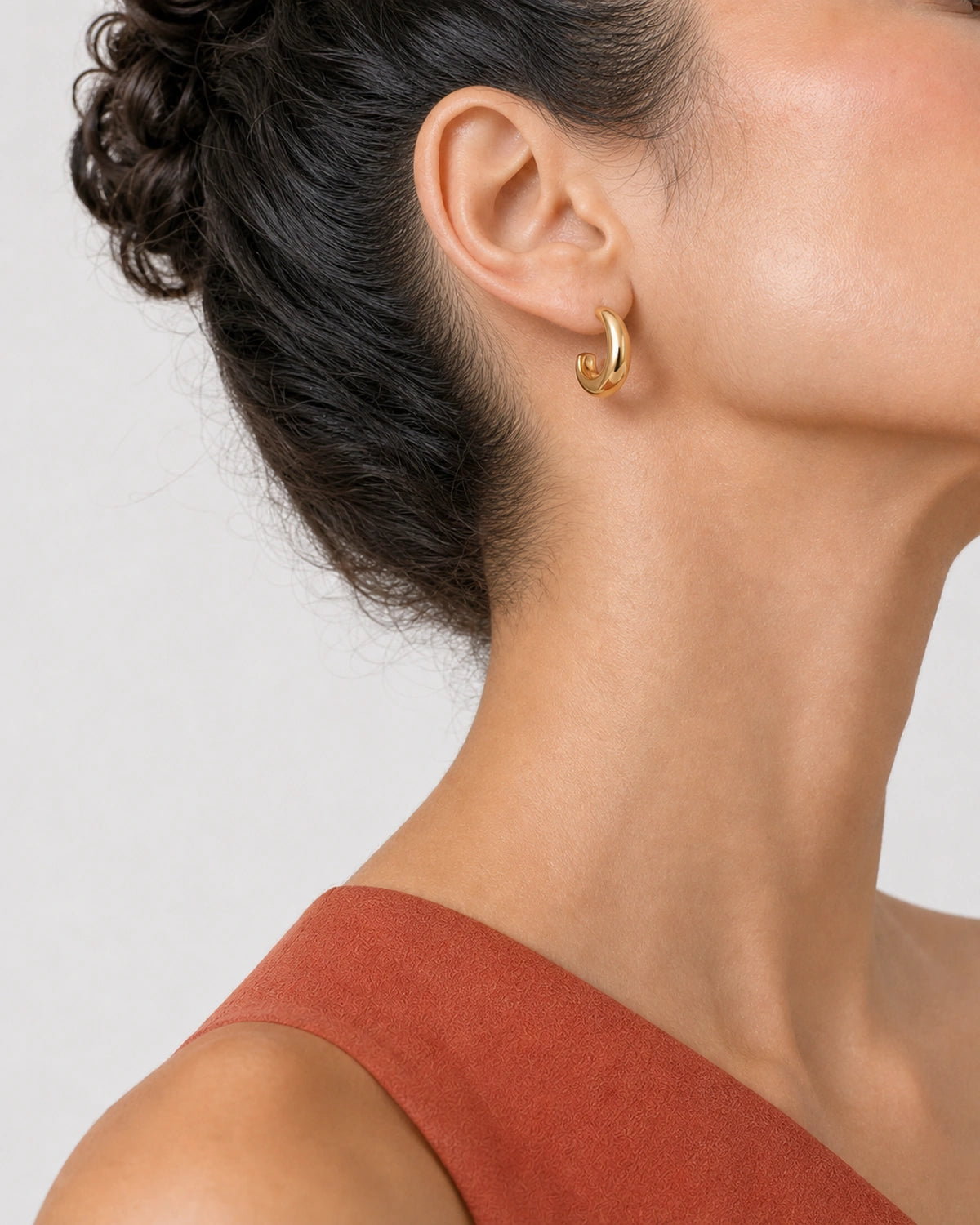 Alternate lower-face wearing view of the Aurelle gold sculpted hoop