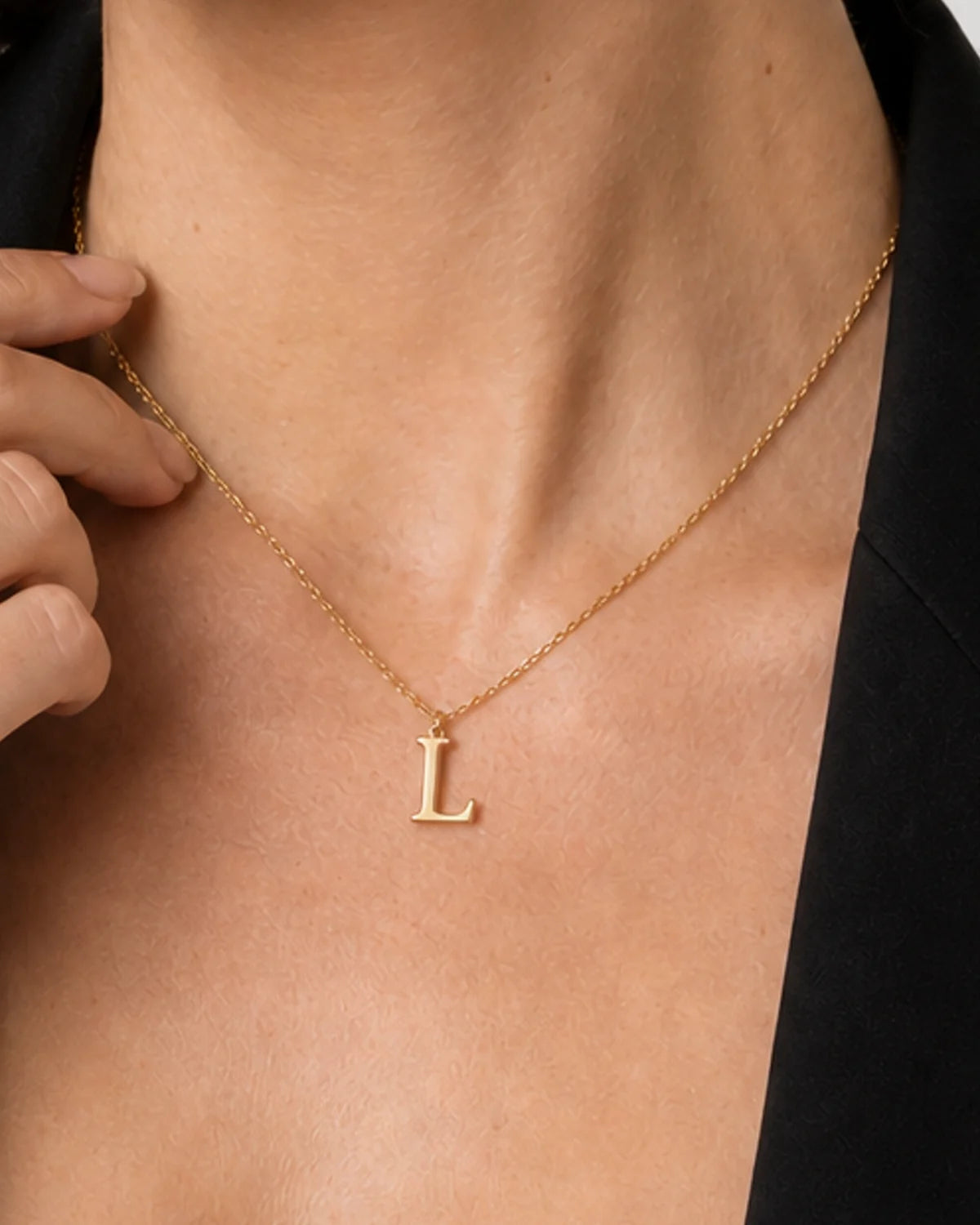 Extreme on-body macro of the polished Aveline serif L charm and integrated bail