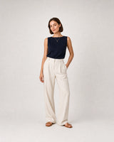 Full-body navy knit and cream linen portrait featuring the Aveline L necklace