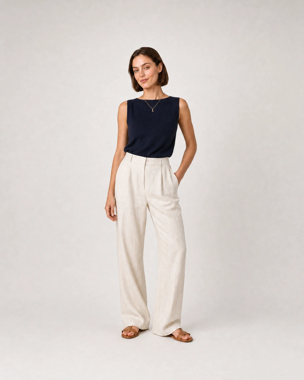 Full-body navy knit and cream linen portrait featuring the Aveline L necklace