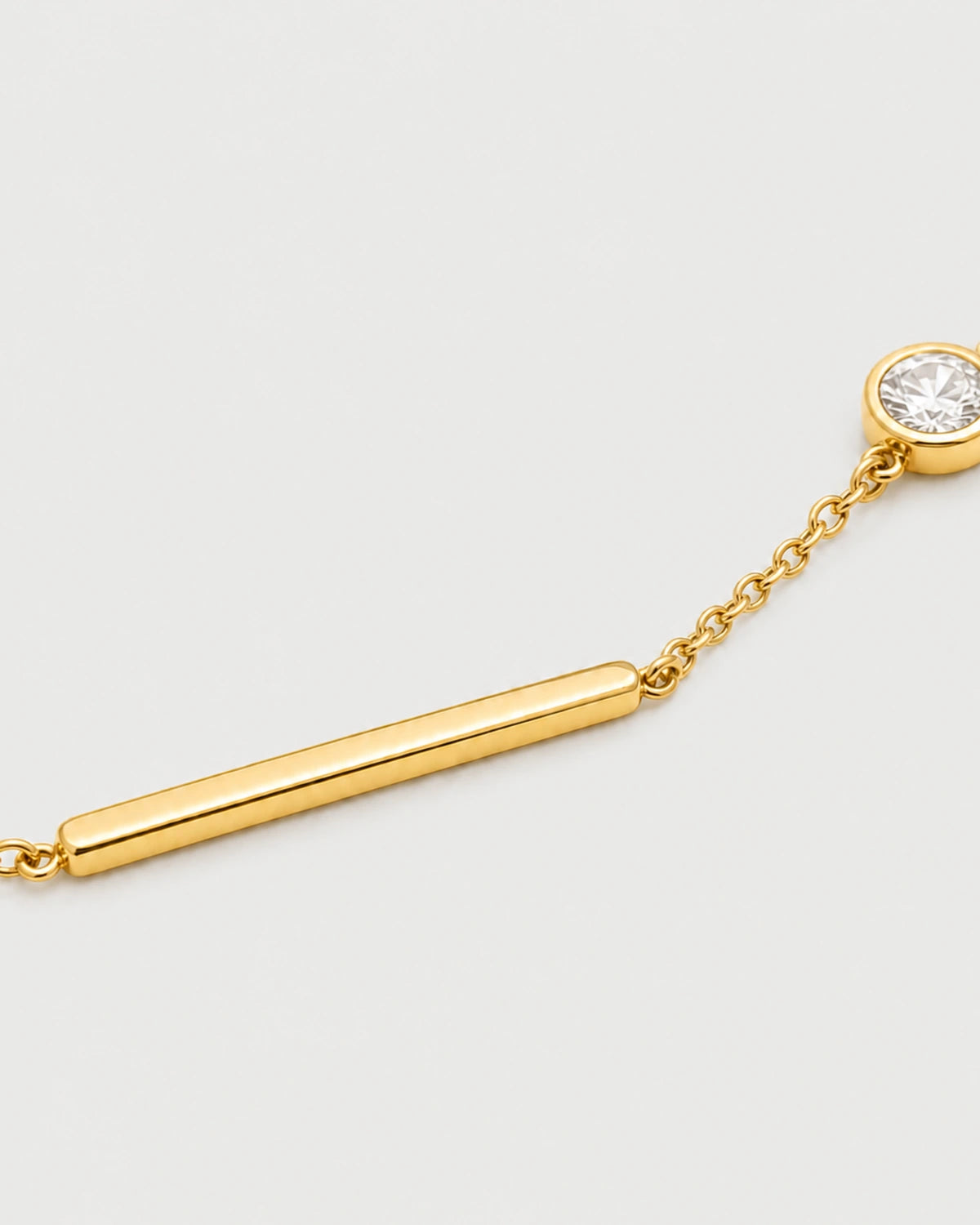Macro of Aven polished gold bar and offset bezel zircon bracelet
