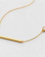 Macro of Aven polished gold bar and offset bezel zircon