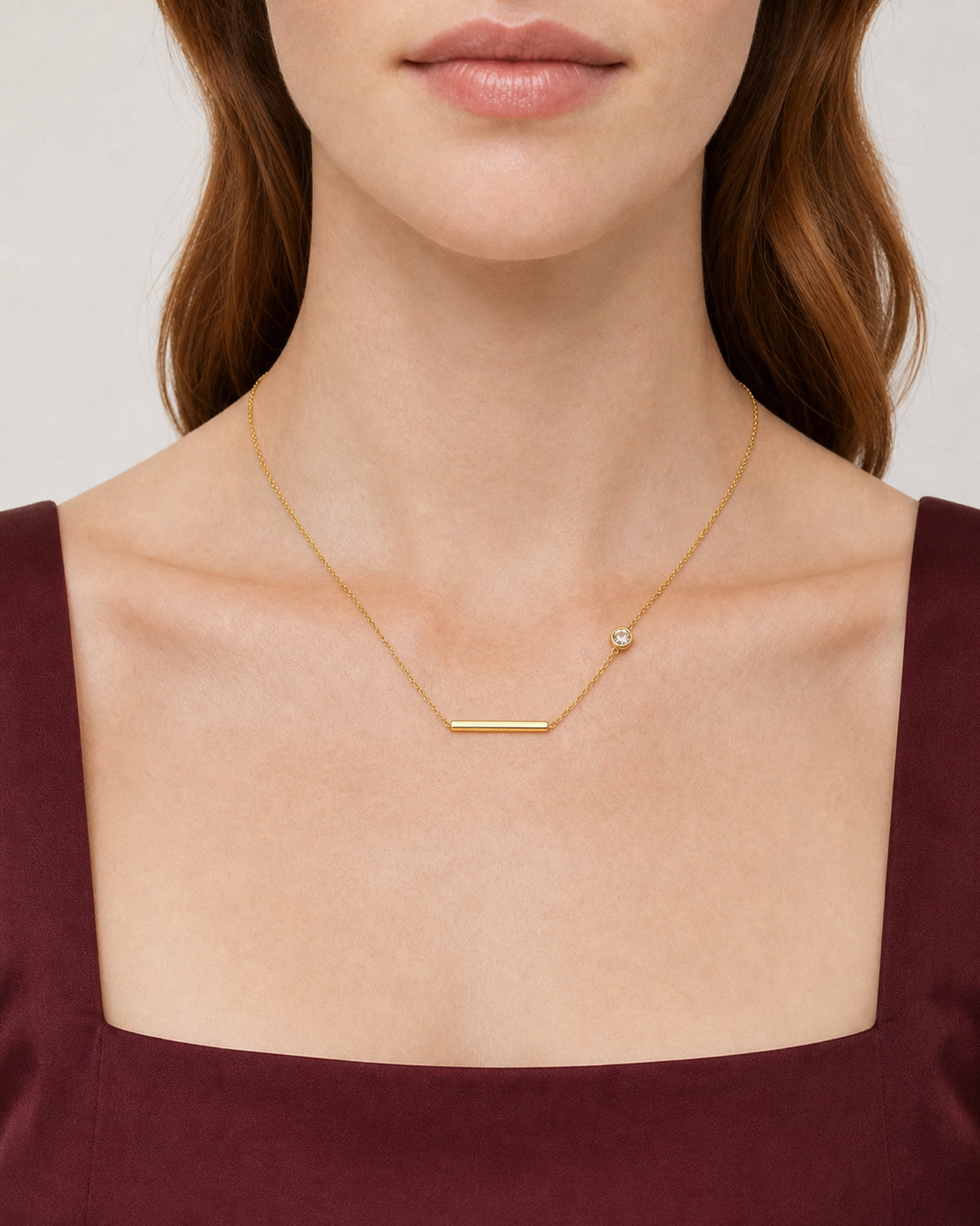Eye-free front neckline portrait of Harriet wearing the Aven gold station necklace