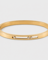 Celene gold floating crystal bangle on a seamless pale dove-grey studio background