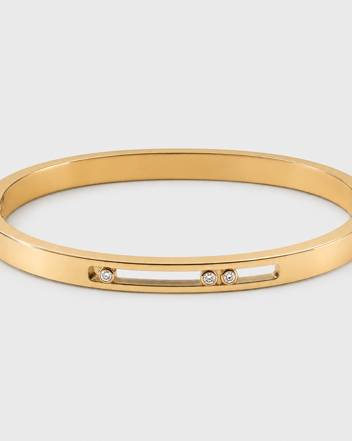 Celene gold floating crystal bangle on a seamless pale dove-grey studio background