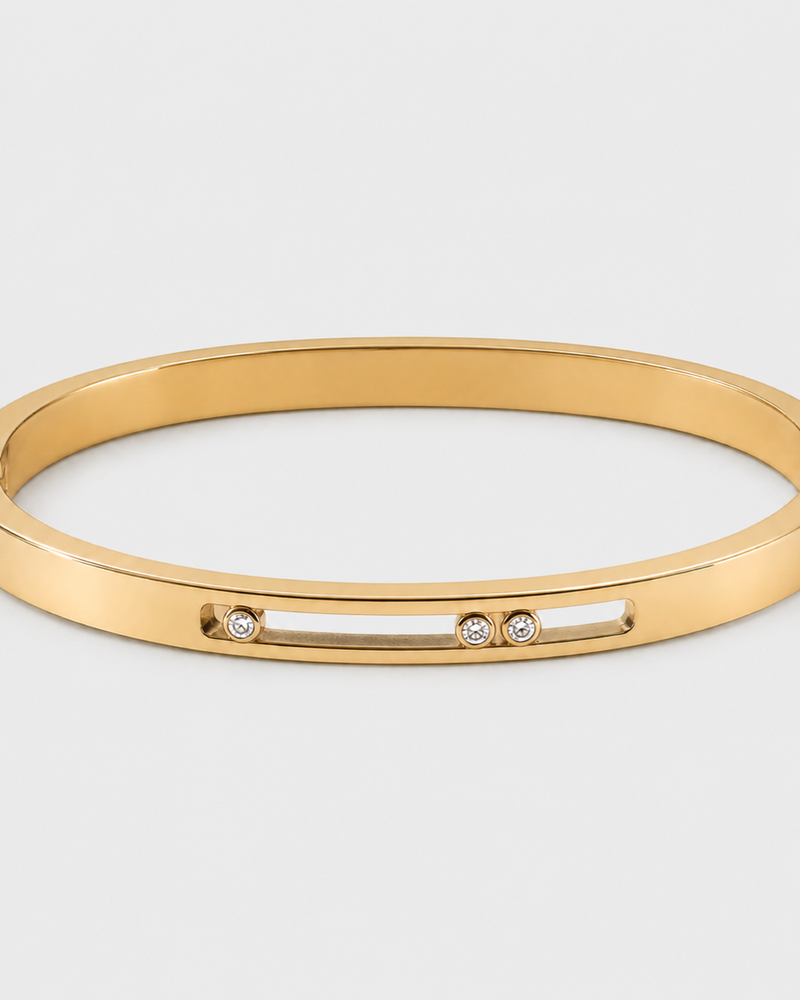 Celene gold floating crystal bangle on a seamless pale dove-grey studio background