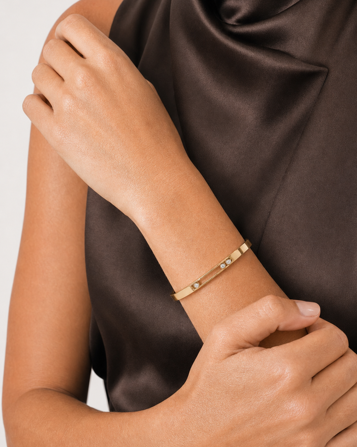 Clean wrist close-up of the Celene slim gold band and three-crystal track