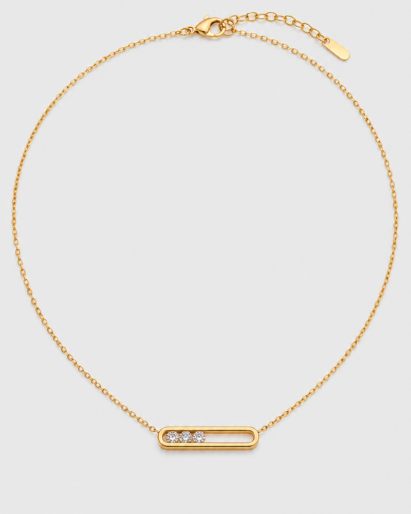 Celene gold floating crystal bar necklace on a seamless pale dove-grey studio background