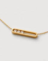 Macro of the Celene open gold bar with exactly three clear crystals grouped at one side