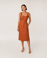 Wide studio portrait in a terracotta linen dress featuring the Célestine necklace