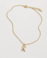 Alternate laid-out view of the Ciel pavé K necklace and oval end tag