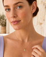 Close wearing view of the petite Ciel pave K pendant and fine gold chain