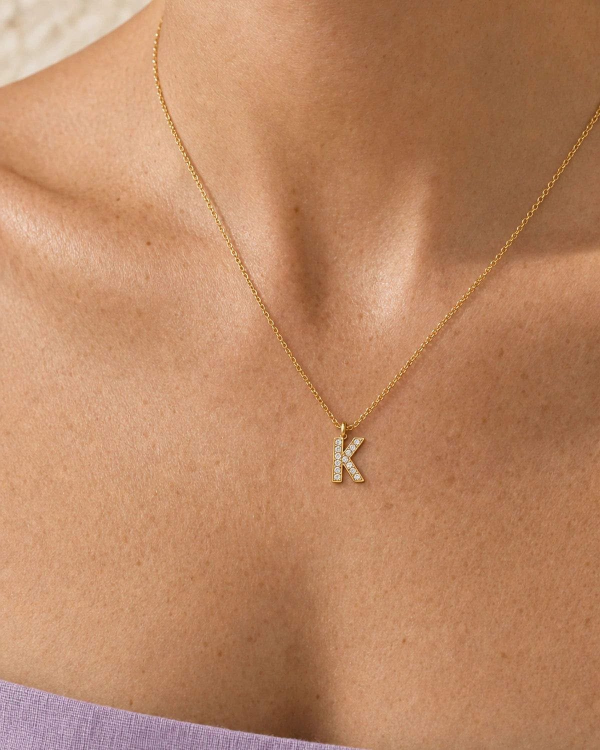 Extreme on-body macro of the Ciel gold K pendant and clear pave stones