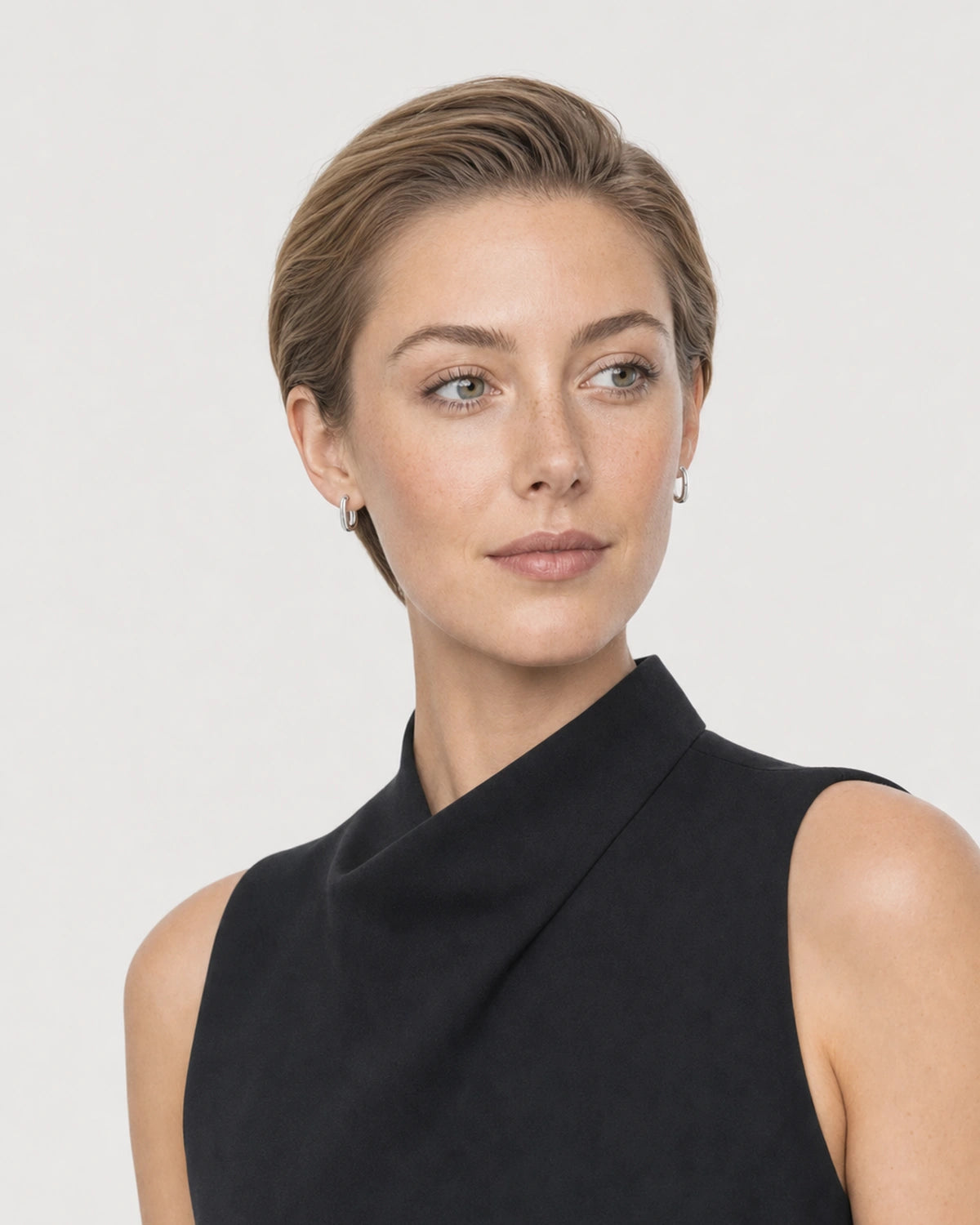 Alternate portrait of the same model wearing the Clea silver huggies