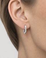 Extreme ear macro of the Clea silver huggie, flush crystal, hinge and catch