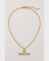 Delphine gold pavé toggle necklace on a pale dove-grey background