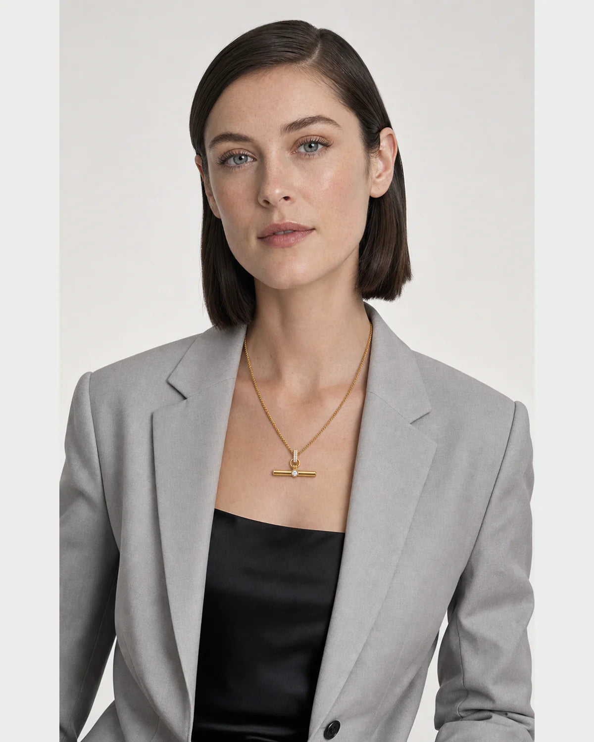 New York model wearing the Delphine toggle necklace with a pale-grey blazer